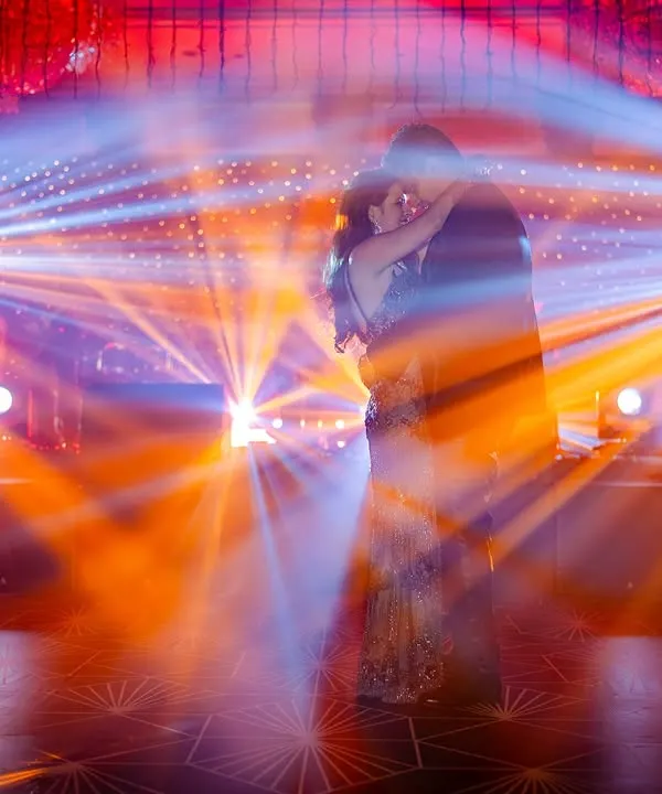 A silhouette of the couple dancing, surrounded by dramatic stage lights. This is a shot that screams 'cinematic'.