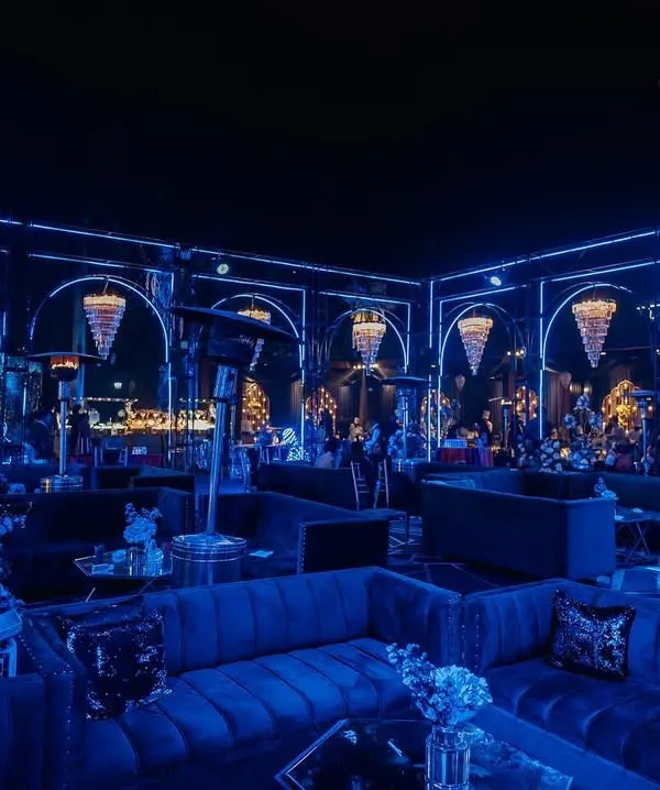 We turned this Sangeet into a high-end, moody lounge with deep blue lighting, plush velvet sofas, and dramatic chandeliers. It's all about creating a vibe.