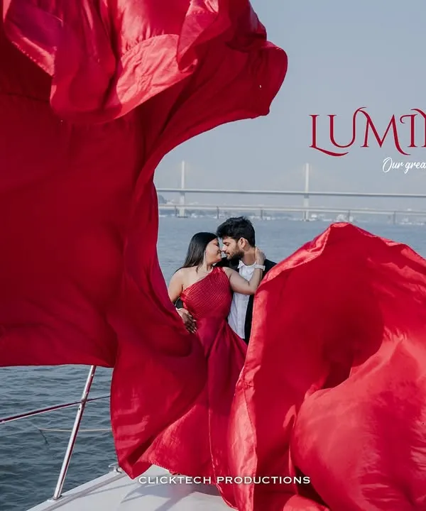 A creative shot from a Goa yacht pre-wedding session, where the bride's vibrant red dress fills the frame, creating a luminous and romantic portrait of the couple.