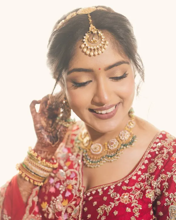 More than a bride, an emotion. Our beautiful bride Saloni glows in a traditional gold necklace with green beads and a matching maang tikka.