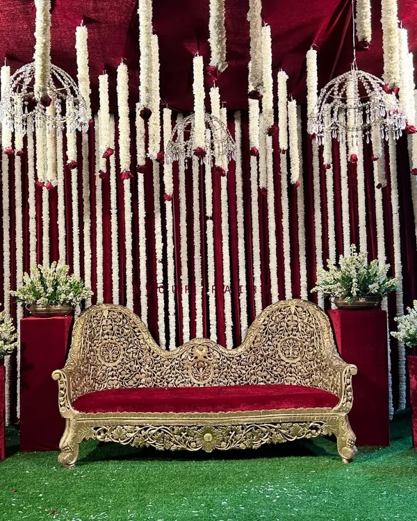 A traditional Godh Baarai (baby shower) setup. We used a rich red and white theme with an ornate sofa and hanging tuberose garlands to create a royal and classic look for the mommy-to-be.