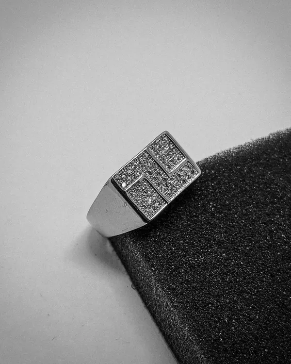 This high-contrast shot highlights the sharp, modern design of our geometric signet ring. The sterling silver band is topped with a pattern of sparkling CZ stones.