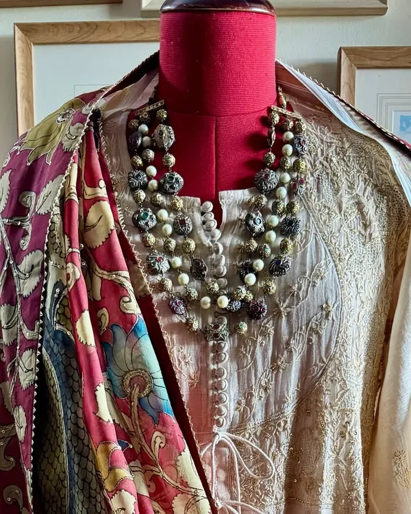 A styled view of our Chikankari tissue chanderi Achkan Anarkali. The ensemble is completed with a hand-painted Srikalahasti Kalamkari dupatta featuring majestic peacock motifs, creating a look of timeless elegance.