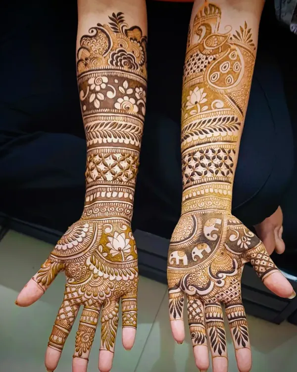 This design prominently features a peacock on the forearm, a classic symbol of beauty and royalty in bridal mehandi.