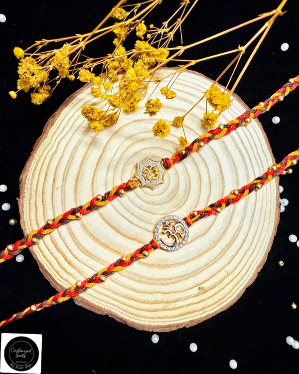 A simple and spiritual 'Om' rakhi. Hand-braided with colorful threads and accented with gold beads, this design is perfect for a brother who appreciates subtlety and meaning.