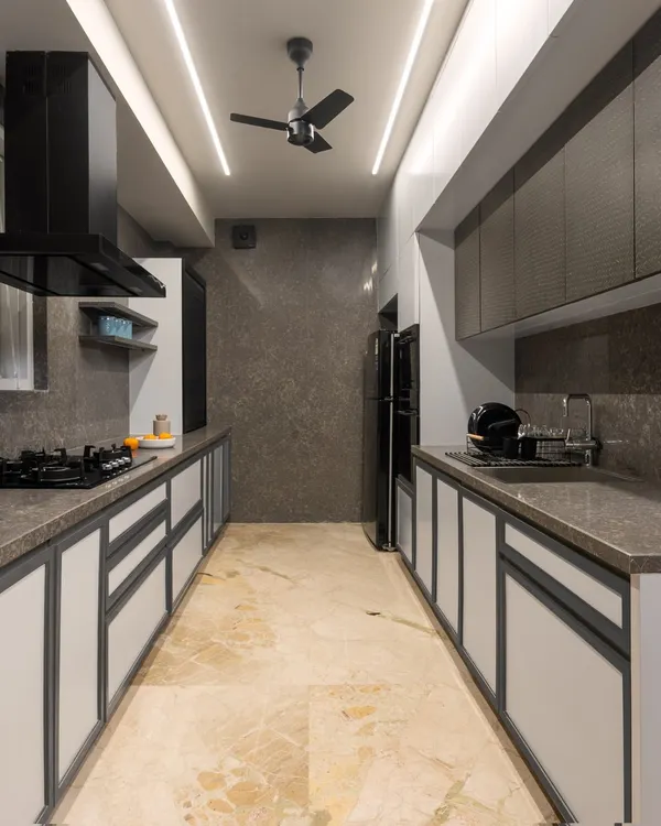 This sleek, parallel kitchen in a modern loft features a monochromatic theme with quartz countertops and minimalist lighting. The design maximizes functionality and maintains a clean, uncluttered aesthetic, perfect for contemporary living.