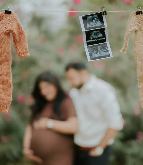 The first sneak peek. This creative announcement shot uses a clothesline with baby outfits and the first ultrasound picture to share the exciting news.