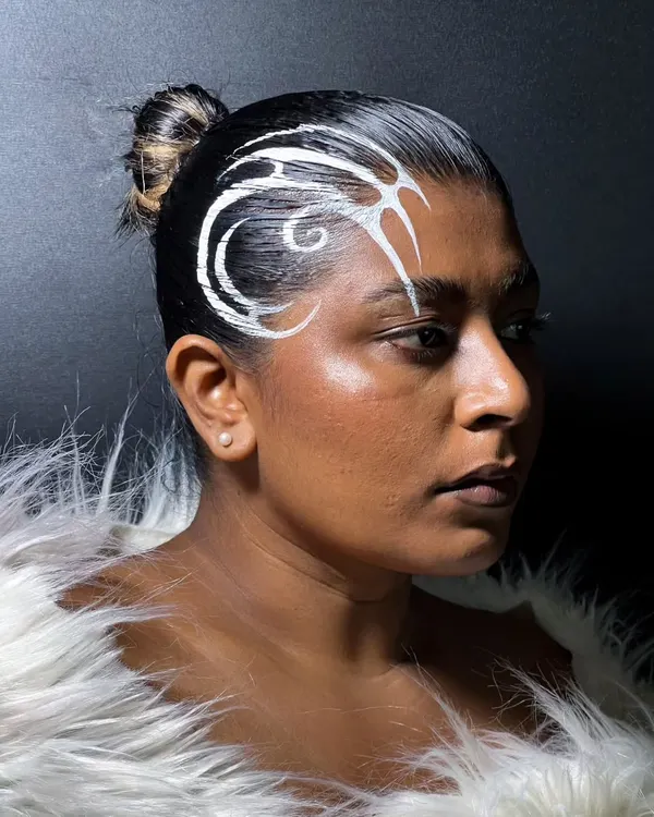 Why limit liner to the eyes? For this experimental look, I painted a graphic white design directly onto the hair for a unique, avant-garde statement.