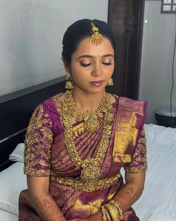 A close-up of my beautiful Dindugal bride Anitha's Muhurtham makeup. The focus is on her eyes, with soft golden-pink eyeshadow and defined liner, paired with a matte plum lip that beautifully complements her purple and gold silk saree.
