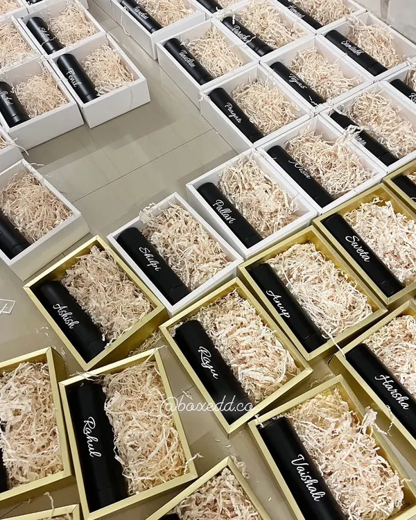 We love the challenge of bulk personalized orders. This image shows rows of gift boxes being prepared, each containing a tumbler customized with a different name for a corporate event.