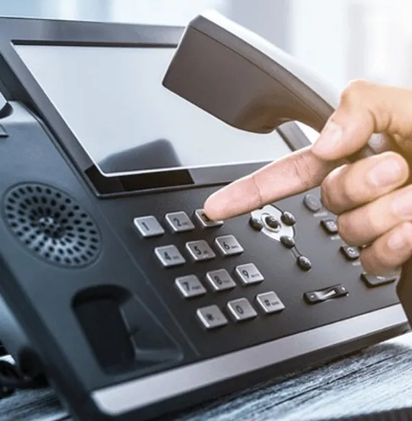 We provide modern enterprise telephony systems that form the backbone of your business communication. This close-up shows a user interacting with an IP-based phone, highlighting the intuitive interface and advanced features that streamline daily call management and internal connectivity.