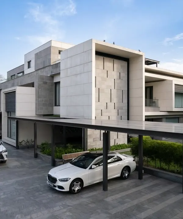 The exterior of Residence 338 features a bold, geometric facade with a covered carport. The design balances privacy with a strong street presence, using a monochrome palette of stone and plaster.