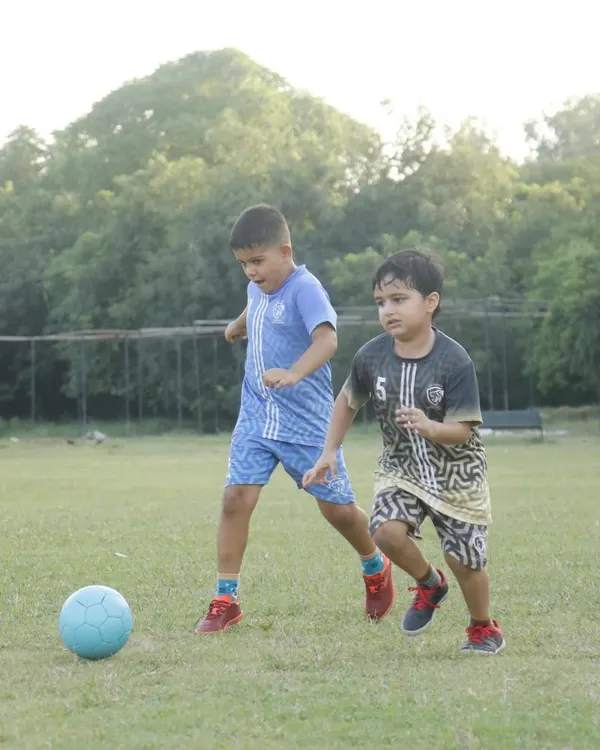 Two young players focused on the ball during a friendly match. Our games are all about participation and giving every child the chance to be part of the action.