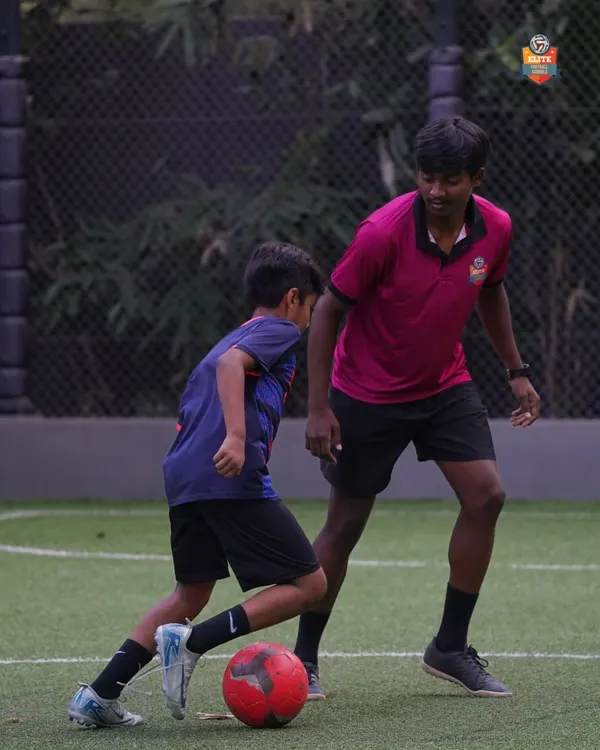 A coach provides detailed instructions to a player during a 1-on-1 session, focusing on defensive stance and positioning. This personalized feedback is key to rapid improvement.