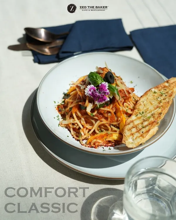 Beyond steaks, I take pride in perfecting comfort classics. This beautifully plated spaghetti is tossed in a rich, house-made sauce and served with grilled garlic bread, representing simple elegance.