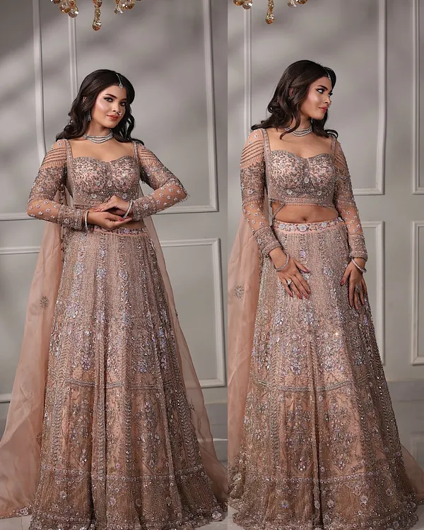 A full view of this stunning engagement bride in her pastel peach lehenga. The soft waves in her hair and the glowing makeup create a dreamy, romantic look.