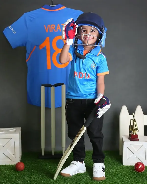 Ready to play for Team India. This little cricketer, complete with a helmet and bat, looks like a future star in our cricket-themed setup. It's a popular choice for young sports fans.