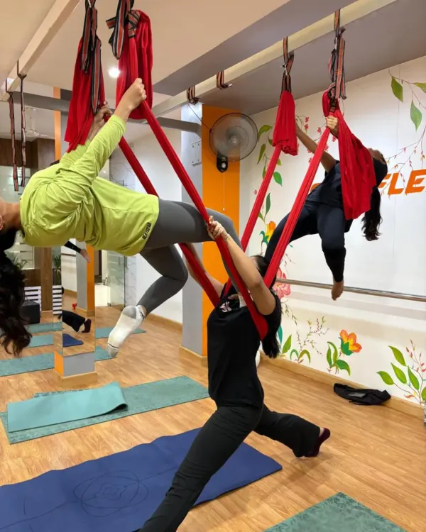 This is what our community looks like in action. We work together, support each other, and create beautiful shapes in the air. This partner-assisted pose builds trust, strength, and is just one example of the dynamic group energy you'll find in our aerial yoga classes.