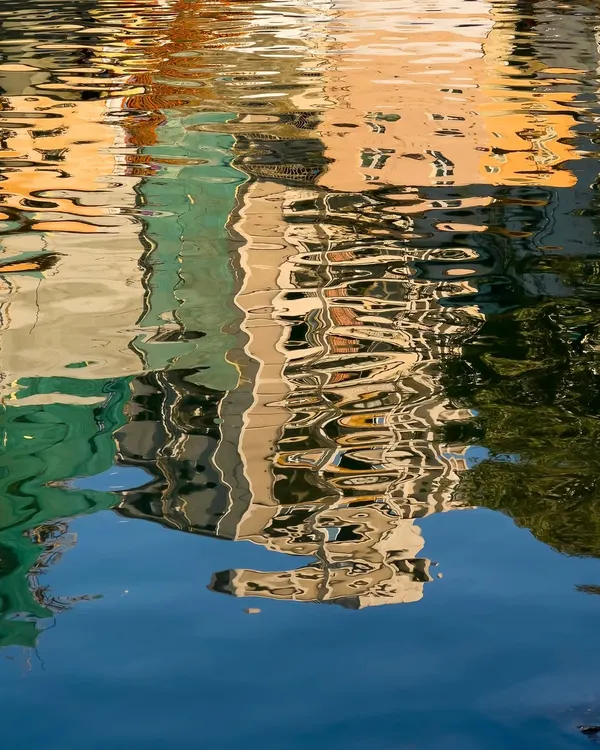 This isn't a painting. It's a photograph of a reflection, where the moving water turns a simple scene into a piece of abstract art.