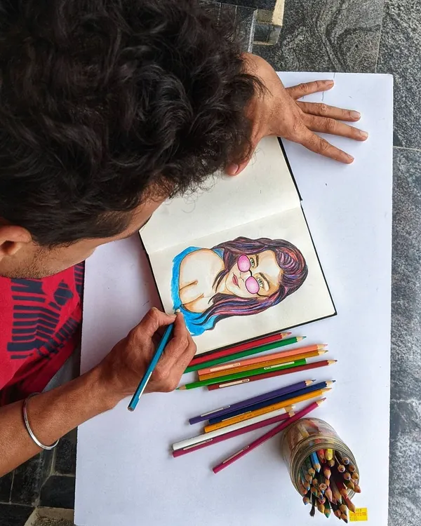 Here I am working on a colorful portrait with colored pencils. This behind-the-scenes view shows the focus and care that goes into every illustration.