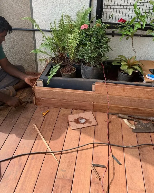 Here you can see the detailed craftsmanship involved in building a custom wooden planter and deck for a high-rise terrace.