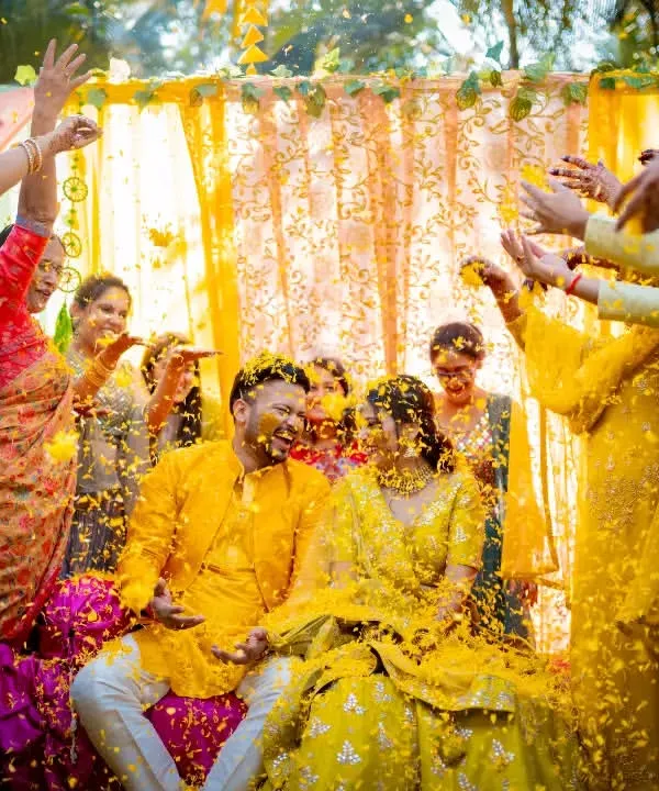 A joyous Haldi moment as the couple is showered with flower petals by their loved ones. We capture the peak of the celebration, full of energy and happiness.