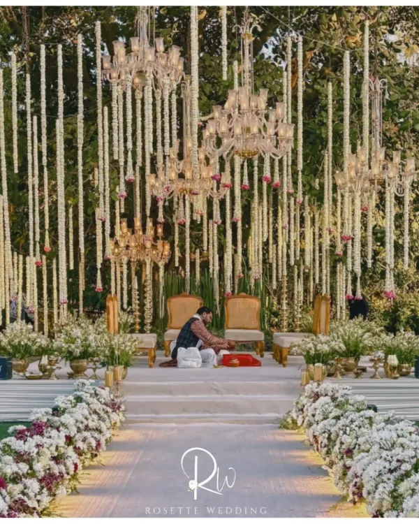 This breathtaking mandap, set against a natural canopy, showcases my passion for creating soulful, elegant spaces. The design features cascading mogra and rose garlands suspended between crystal chandeliers, creating a dreamscape where nature and luxury meet for a truly unforgettable ceremony.