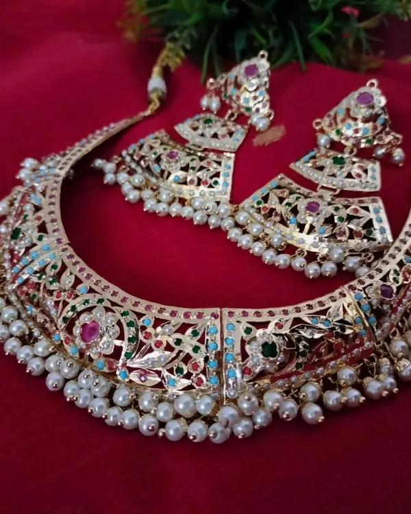The 'सुहानी' (Suhani) necklace set is a masterpiece of Jadau work. This grand choker features intricate multi-coloured stones and pearls, perfect for a bride or for making a royal statement at any grand occasion.