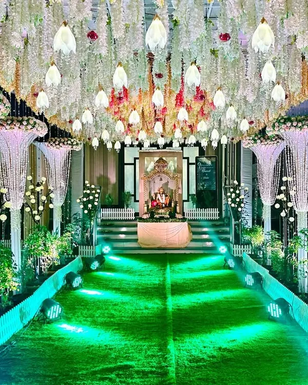 A classy and opulent reception entrance we designed. The pathway is lined with stunning pearl and crystal chandeliers hanging from the ceiling, leading to a Ganesha idol, creating a breathtaking first impression for guests.