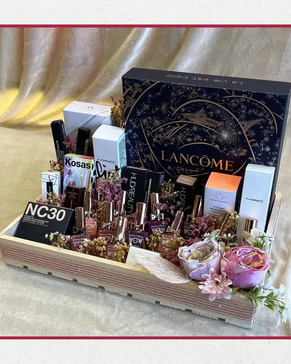 A makeup lover's dream come true. This stunning hamper features a huge collection of high-end products from brands like Lancôme, Huda Beauty, MAC, and Kosas, all beautifully arranged in a wooden tray.