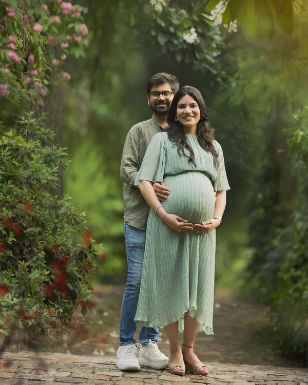 A sweet and natural moment between an expecting couple, surrounded by the lush greenery of a Delhi park. Outdoor sessions like this are perfect for capturing relaxed, authentic interactions and love.