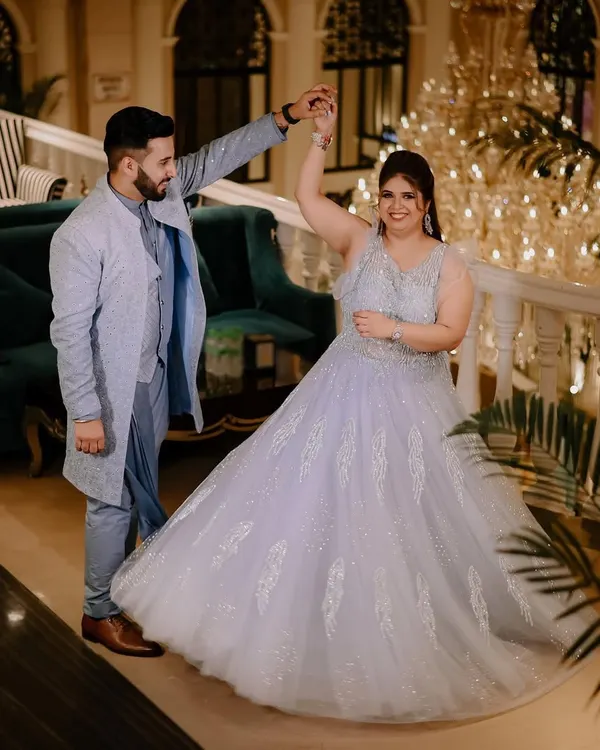 A beautiful moment from a ring ceremony, where the couple shares a dance. The grand chandelier and elegant setting add to the fairytale feel of this engagement party.