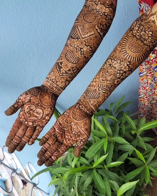 A perfect example of personalization. This bridal design features a beautiful heart in the center of the palm with the phrase 'Raja weds Rani' written inside, making it so special for the couple.