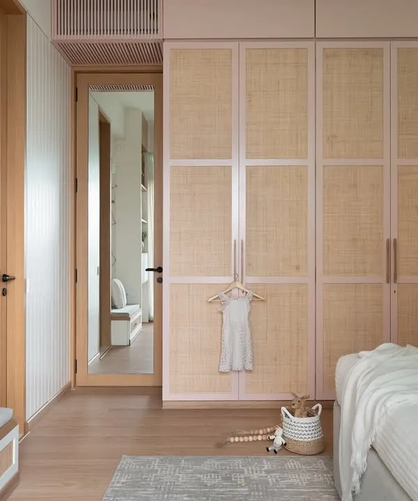 For a delightful 3-year-old client with a passion for pink, her dream bedroom came to life. The blush pink wardrobes with a rattan blend and a pastel rainbow mural make this a magical, personal haven.