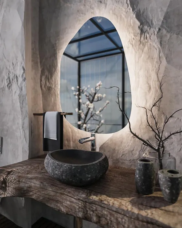 We designed this powder room to be a unique, immersive experience. It features raw, cave-like stone walls, a live-edge wood countertop, and a vessel sink carved from a single piece of stone, all illuminated by a modern backlit mirror.