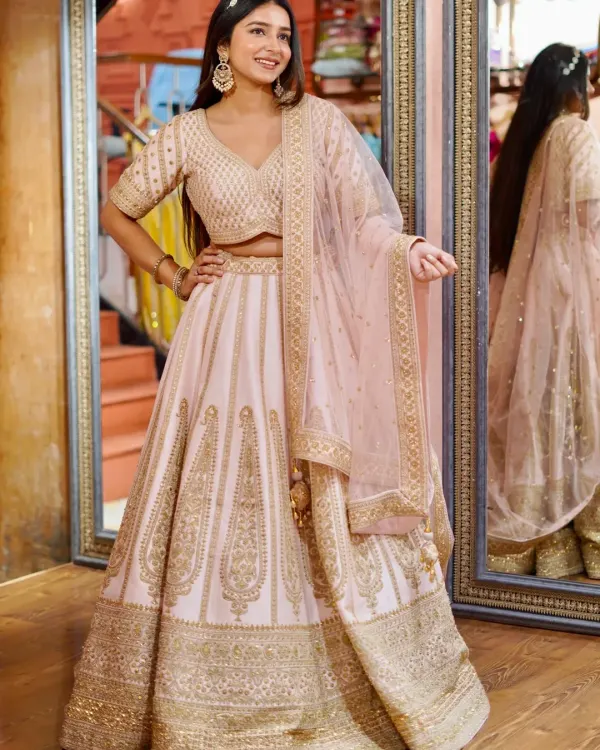 Pastel perfection for a daytime celebration. This light pink lehenga with delicate gold embroidery is soft, romantic, and gives you an ethereal glow.