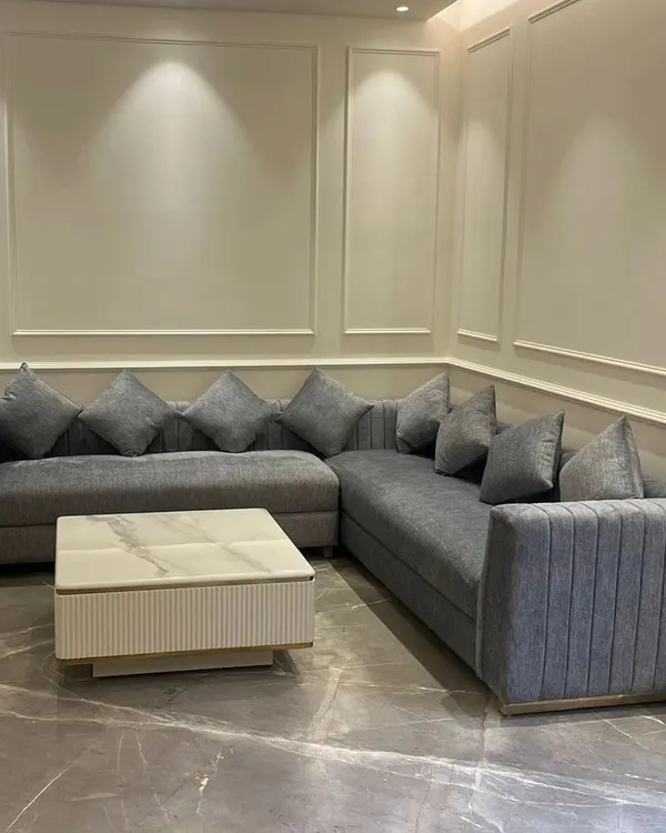 A custom L-shaped sectional sofa we designed for a contemporary living room. This piece features clean lines, plush grey upholstery, and a fluted design on the armrest, providing ample seating without compromising on style.