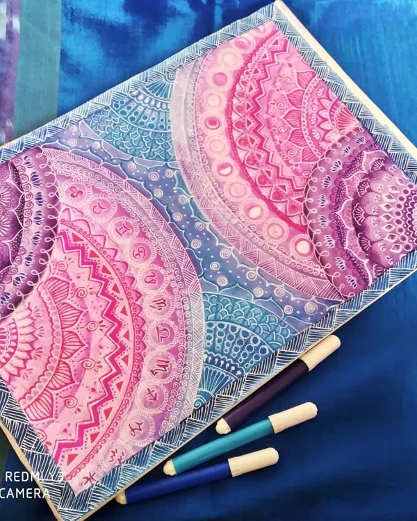 This is my 'Galaxy Mandala' series, where I blend intricate geometric patterns with the colors of deep space. Each section is carefully detailed with fine-line markers, transitioning from cosmic blues to vibrant purples and pinks to create a sense of depth and wonder.