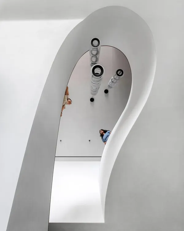 The sculptural staircase in the Worli Duplex is the defining element of the home. Its sweeping form creates a dynamic visual anchor that breaks from the apartment's otherwise orthogonal geometry.