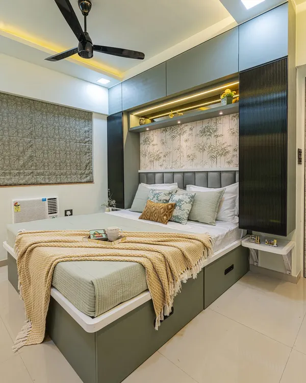 This bedroom is designed to be a calm retreat. I used a soothing green and beige color palette, a nature-themed wallpaper, and overhead storage to maximize space while keeping the room feeling uncluttered and serene.