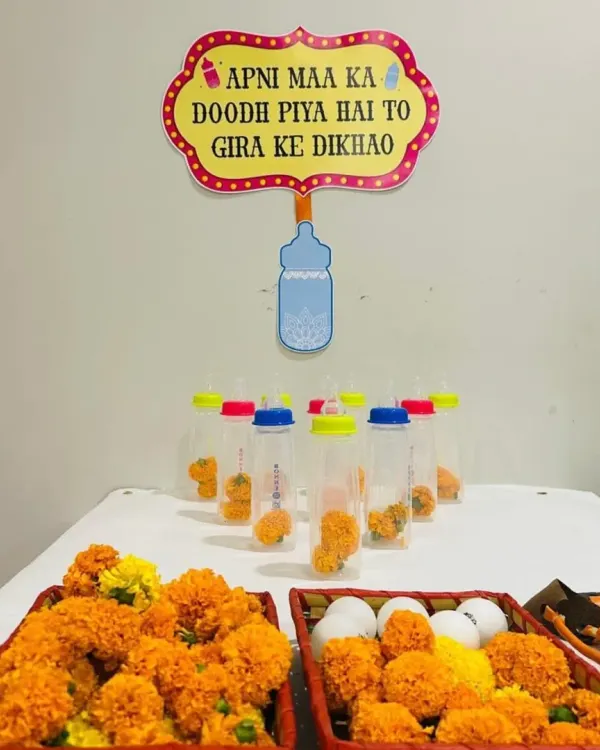 We love adding a dose of humor to our events. This baby bottle bowling game, set up with marigolds and a funny sign, is a perfect icebreaker and a fun activity for guests at a Godh Bharai.