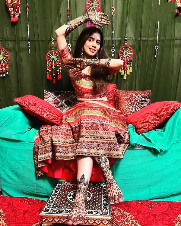 A stunning bride showcasing her full bridal look, with intricate mehndi on both her hands and feet. The designs are coordinated to create a cohesive and breathtaking appearance for her wedding day.