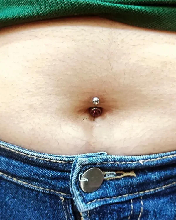 The final result of a classic belly button piercing, centered and fitted with a simple, high-quality barbell. My goal is a piercing that heals well and looks great.