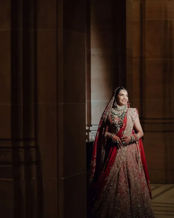 A full-length view of Nikita's timeless Anamika Khanna lehenga. We wanted a regal look that complemented the grandeur of Umaid Bhawan, and this outfit was the perfect choice for her red bride vision.