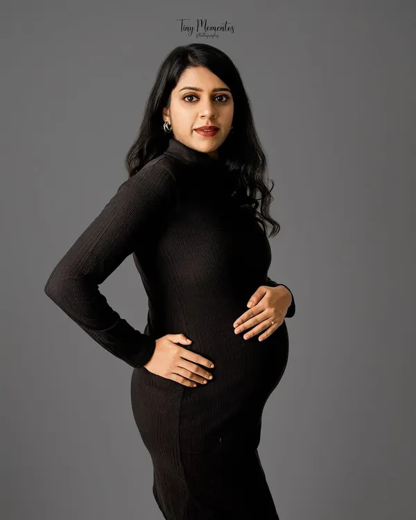 A classic three-quarter portrait in a simple black dress against a solid grey backdrop. This minimalist approach puts all the focus on your beautiful form and expression.