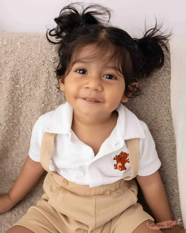 That mischievous little smile! This close-up portrait of a toddler in a classic outfit captures his charming and playful personality perfectly.