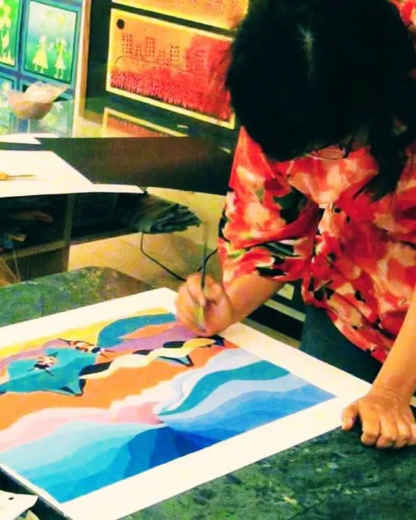 An adult student finds her flow, carefully adding details to a colorful landscape painting. My classes provide a tranquil space for you to unwind and focus on your art.