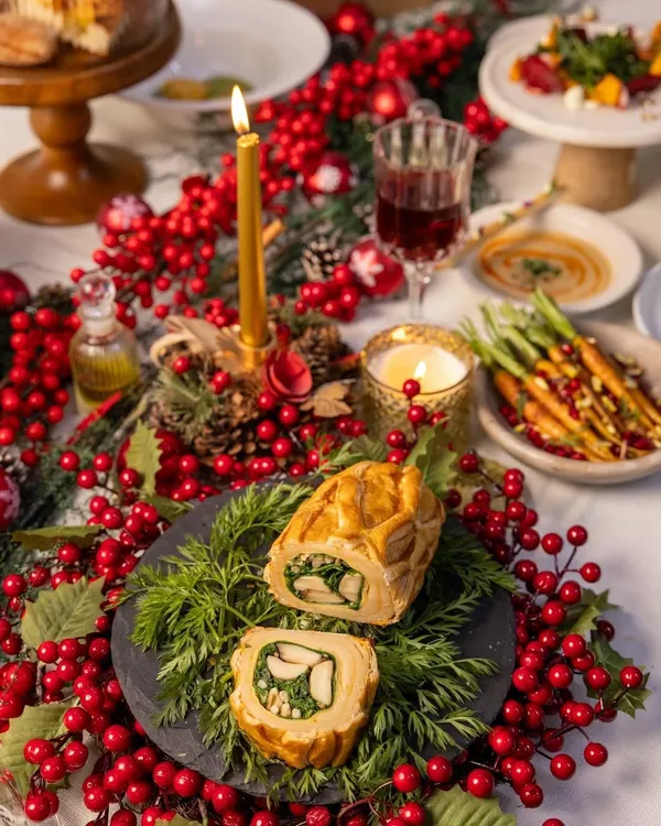 The centerpiece of our Holiday Feast, a magnificent Chicken Wellington, sliced and ready to be served amidst a festive, candlelit table setting.