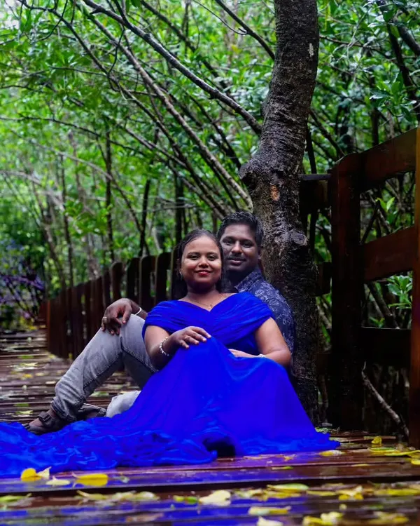 A serene maternity shoot on a wooden bridge, featuring a simple yet elegant blue gown.