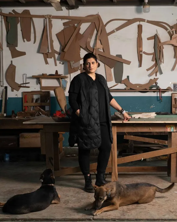 In my workshop, surrounded by my loyal companions. This is my sanctuary, where I am not just a designer, but a hands-on creator. The templates on the wall are the ghosts of past projects, each one a story of a design brought to life.